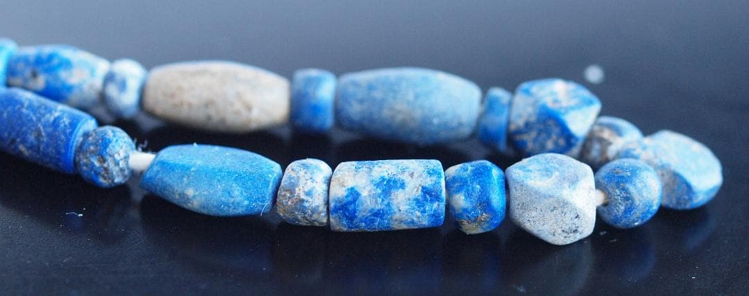 古代濃紺ラピスの管玉や丸玉をほぼ左右対称に編み、トップに斧型や多面体、80個の連